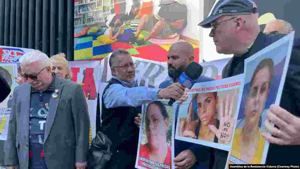Miembros de la Asamblea de la Resistencia sostienen carteles con las imágenes de presos políticos cubanos. Lech Walesa (izq.) los acompaña. 