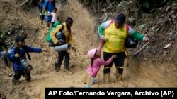 ARCHIVO: Migrantes con niños atraviesan la selva del Darién rumbo a Panamá en su ruta hacia Estados Unidos, el 15 de octubre de 2022. (AP Foto/Fernando Vergara, Archivo)