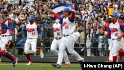 Peloteros cubanos celebran después de la victoria del equipo sobre Taiwán durante un juego del Grupo A del Clásico Mundial de Béisbol, en el Estadio Intercontinental de Béisbol de Taichung, en Taiwán. (Foto AP/I-Hwa Cheng)