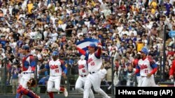 Peloteros cubanos celebran después de la victoria del equipo sobre Taiwán durante un juego del Grupo A del Clásico Mundial de Béisbol, en el Estadio Intercontinental de Béisbol de Taichung, en Taiwán. (Foto AP/I-Hwa Cheng)