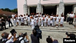 Las Damas de Blanco posan para fotos sosteniendo flores y vestidas de blanco durante su protesta semanal exigiendo la libertad de los presos políticos, el 25 de marzo del 2012. (REUTERS/Jorge Silva).