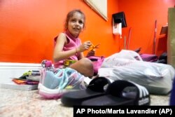 Delmis Benbow, de 8 años, niña cubana que llegó por mar a Florida junto a su madre y dos hermanos, abre la mochila escolar donada a la iglesia Rescate de Hialeah
