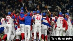 Peloteros cubanos celebran la victoria frente a Australia que le sdio el pase a la semifinal de este domingo frente a EEUU. (AP/Toru Hanai)