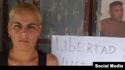 Esposa de Duniesky Ruiz, junto al cartel que pide la liberación del preso del 11J.