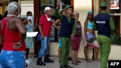 Policías controlan la multitud en una cola para comprar alimentos en La Habana. (YAMIL LAGE / AFP)