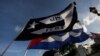 Exiliados ondean banderas cubanas frente al restaurante Versailles de Miami en solidaridad con las protestas en la isla. (REUTERS/Marco Bello)