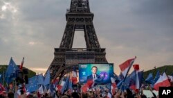 Emmanuel Macron celebra la victoria junto a sus seguidores frente a la torre Eiffel, en París. (AP/Rafael Yaghobzadeh)