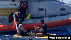 Un equipo de la estación de la Guardia Costera de Key West rescata a dos cubanos de una balsa flotante, a unas 9 millas al sur de Ramrod Key, Florida, el 3 de mayo. (Foto: USCG)