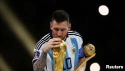Lionel Messi, de Argentina, besa el trofeo de la Copa del Mundo después de recibir el premio Balón de Oro tras ganar el mundial 2022. (REUTERS/Kai Pfaffenbach/File Photo).
