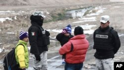 Una familia de migrantes cubanos es aprehendida por la Guardia Nacional antes de cruzar el Río Bravo en la frontera con Estados Unidos, en Ciudad Juárez, estado de Chihuahua, México, en febrero de 2021. (AP/Christian Chavez)