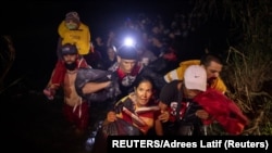 Un grupo de migrantes, entre ellos un cubano de 48 años, llega a suelo estadounidense por la frontera sur, el 9 de abril de 2022. (Reuters/Adrees Latif).