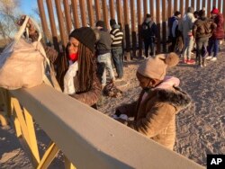 Una cubana y su hija hacen fila en la frontera sur para ser trasladadas por la Patrulla Fronteriza a Yuma, Arizona, el 6 de febrero de 2022, con la esperanza de permanecer en Estados Unidos para solicitar asilo.