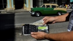 Un hombre muestra su billetera con dólares estadounidenses, en La Habana, Cuba. (YAMIL LAGE / AFP)