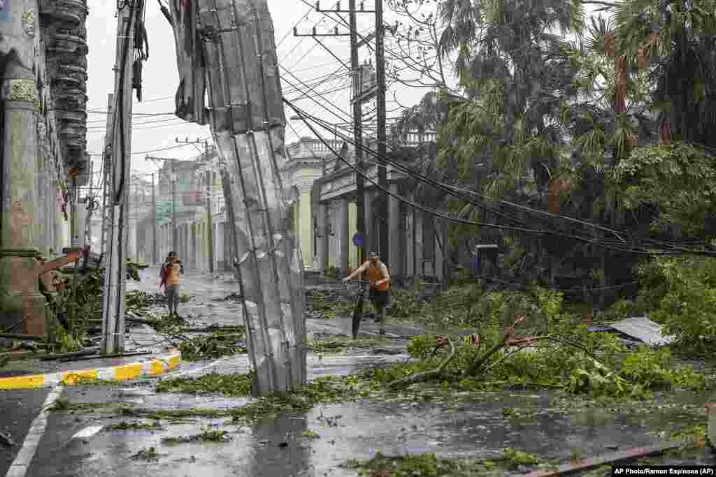 Postes de luz caídos bordean una calle después de que el huracán Ian azotara Pinar del Río, Cuba, el martes 27 de septiembre de 2022.