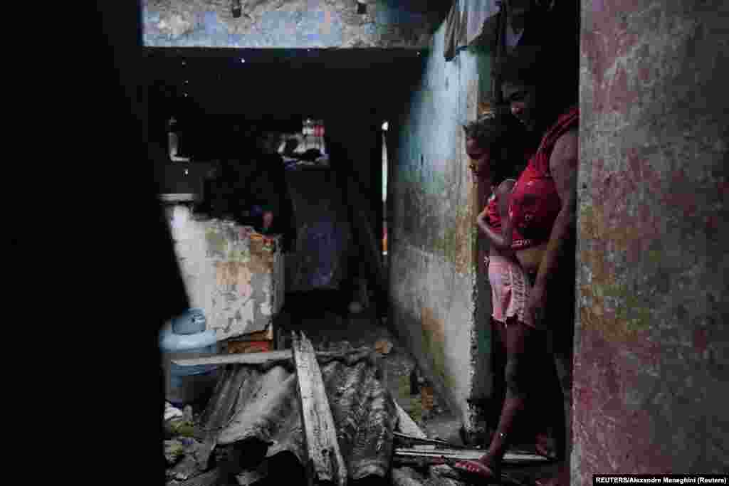 Luzanne de la Castro y su hija se paran en la puerta de su casa dañada después del huracán Ian en Pinar del Río, Cuba, 27 de septiembre de 2022. REUTERS/Alexandre Meneghini