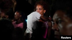 Una madre con su hijo en brazos protesta frente a la sede del Partido Comunista en La Habana, el 29 de septiembre de 2022. (REUTERS/Alexandre Meneghini)