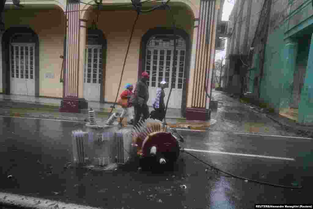Postes de luz caídos bordean una calle después de que el huracán Ian azotara Pinar del Río, Cuba, el martes 27 de septiembre de 2022.