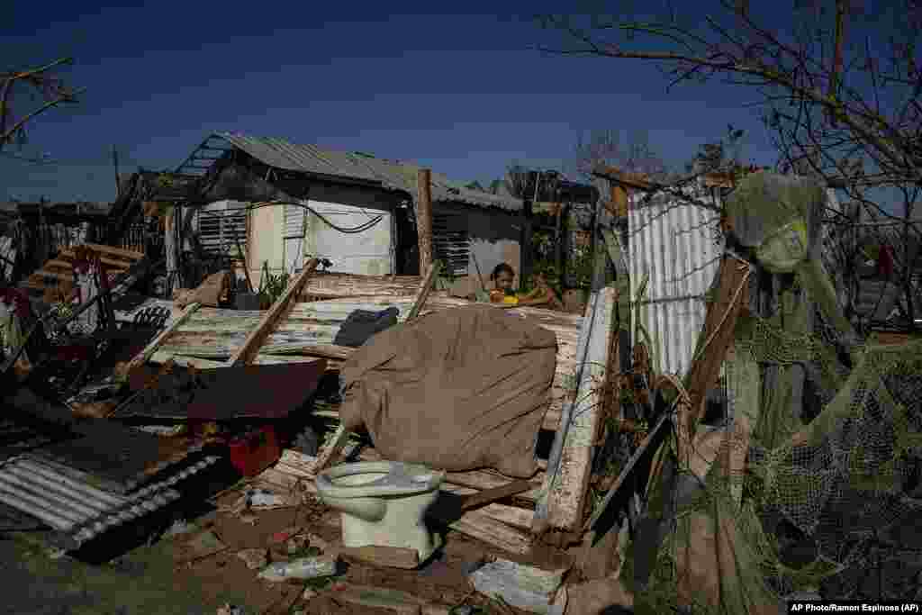 Una joven juega entre los restos de una casa destruida por el huracán Ian en La Coloma.