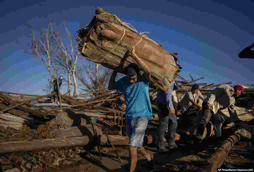 Trabajadores recuperan tabaco de un secadero que fue destruido hace una semana por el huracán Ian en La Coloma.