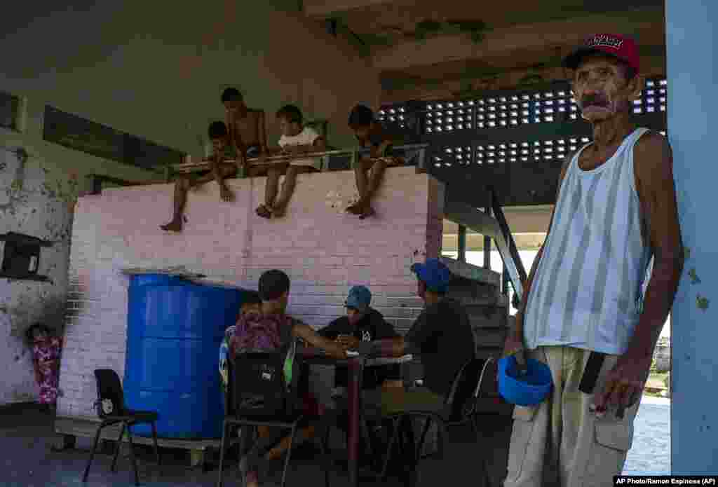 Un residente que quedó sin hogar por el huracán Ian sostiene un plato vacío mientras espera su turno para comer en una escuela convertida en albergue en La Coloma.