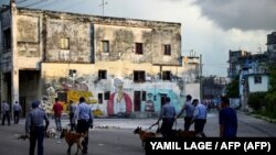 Policías con perros recorren las calles de La Habana el 11 de julio pasado, día en que estallaron las protestas antigubernamentales en varias localidades de Cuba. (AFP/Yamil Lage).