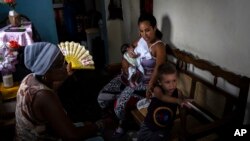 Foto Archivo. Madre abanica a su hija y sus nietos durante un apagón en Regla, La Habana