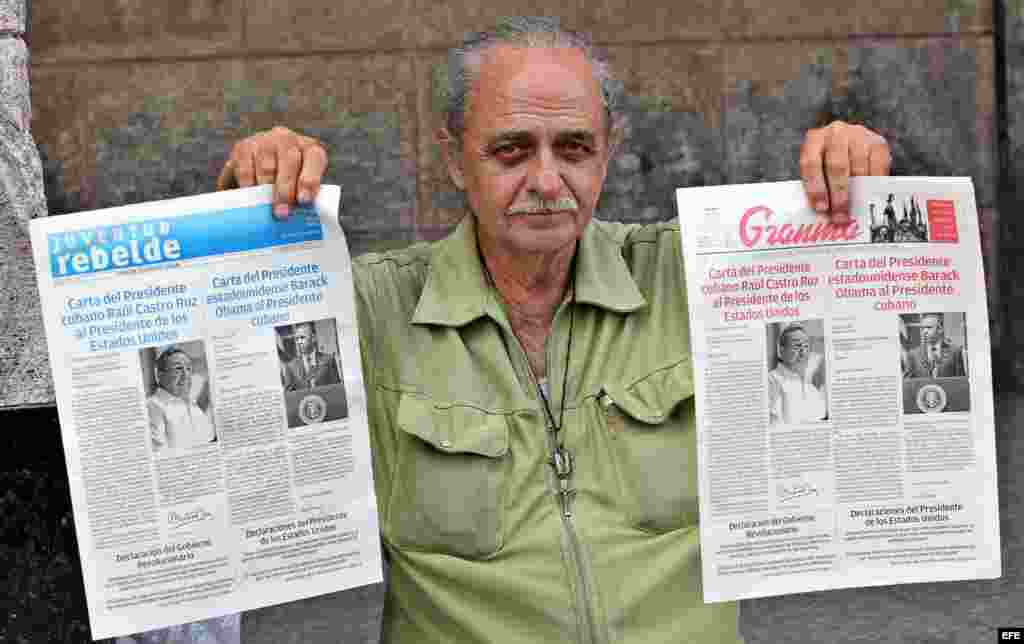 Un vendedor de periódicos en La Habana muestra el diario oficial Granma y Juventud Rebelde, con la misma portada.