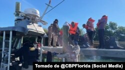 Agentes custodian a un grupo de inmigrantes que desembarcaron en Cayo Marathon, Florida.