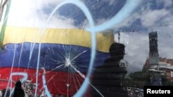 La bandera venezolana es vista a través de un cristal roto durante una manifestación contra Nicolás Maduro en Caracas. (Archivo)