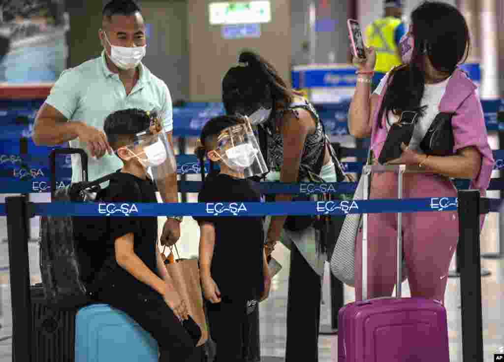 Una familia en el Aeropuerto Internacional Jos&#233; Mart&#237; de La Habana, con m&#225;scaras de protecci&#243;n contra el coronavirus, tras la reapertura de la terminal a&#233;rea. (AP Photo/Ramon Espinosa) 