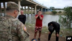 Migrantes cubanos interceptados por agentes de la Guardia Nacional estadounidense tras cruzar a nado el Río Bravo, en Eagle Pass, Texas. (AP/Dario Lopez-Mills)
