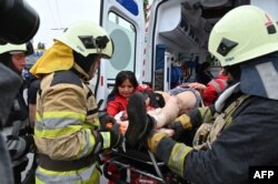 Paramédicos suturan de emergencia a un herido en la ciudad de Kharkiv, Ucrania, antes de ser enviado al hospital