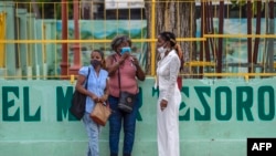Familiares de Luis Manuel Otero Alcántara y Maykel Castillo "El Osorbo" esperan frente al Tribunal de Marianao donde tiene lugar el juicio en contra de los artistas. (Yamil LAGE / AFP)