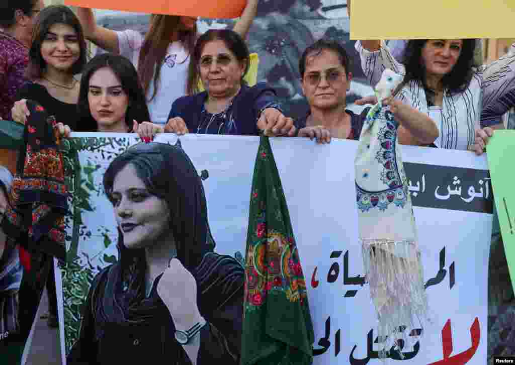 Un grupo de mujeres sostiene una foto de Mahsa Amini y se quitan el hiyab , en la Plaza de los Mártires en Beirut, Líbano.