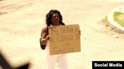 Berta Soler protesta este domingo frente a laq sede de las Damas de Blanco con un cartel en contra de la aprobación del nuevo Código de las Familias. (Foto: Facebook)