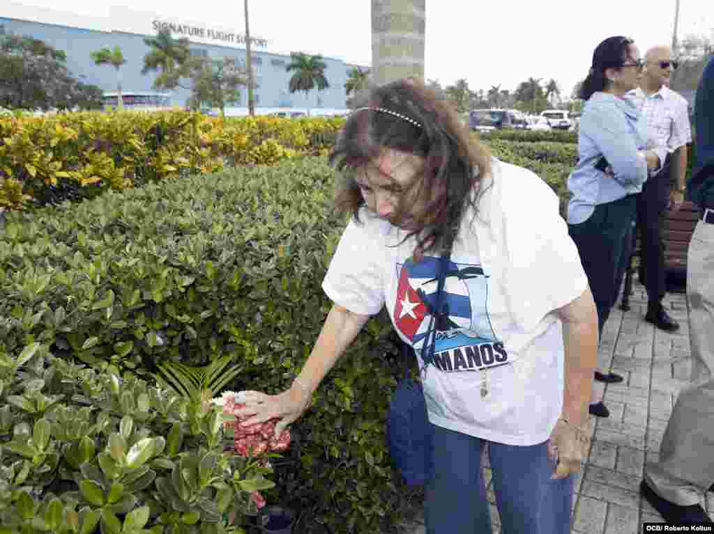 Mirian Campos pone flores en una de las tarjas dedicadas a los jóvenes pilotos.
