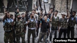Varios miembros del ejército rebelde ostrando sus armas y gritando consignas en contra del régimen del presidente sirio, Bachar al Asad en la ciudad de Alepo, Siria.
