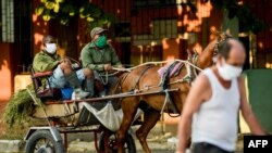 Cubanos se protegen con mascarillas del contagio de coronavirus. YAMIL LAGE / AFP