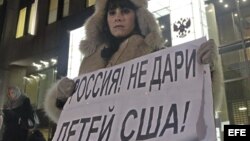 Una mujer protesta en contra de la prohibición de adopción de huérfanos rusos a ciudadanos americanos a las puertas del Consejo de la Federación en Moscú (Rusia). 26 de diciembre de 2012.