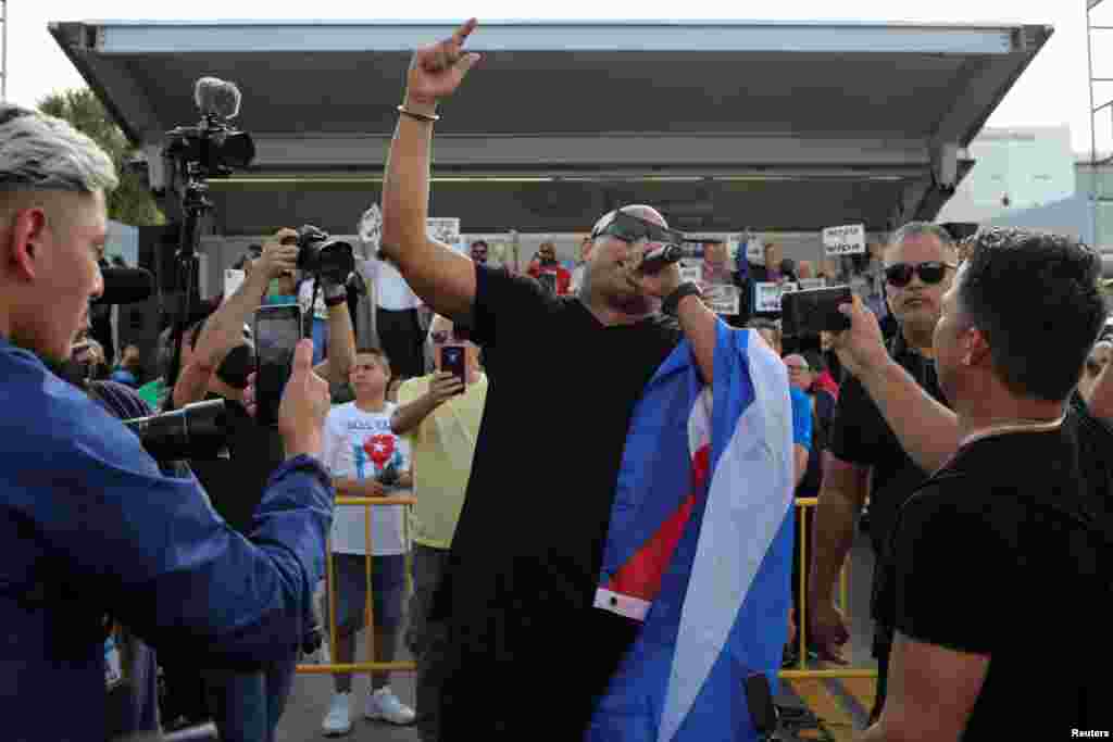 El músico Alexander Delgado, miembro de la banda cubana de reguetón Gente de Zona, habla durante un mitin de solidaridad con los manifestantes en Cuba, en el barrio de La Pequeña Habana, en Miami, Florida, el 14 de julio de 2021. Foto: REUTERS / Marco Bello.