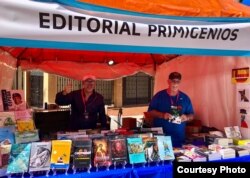 El autor, a la derecha, posa en el stand de la Feria del Libro.