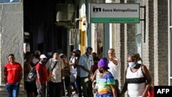 Cubanos hacen cola frente a un banco en La Habana. (YAMIL LAGE / AFP)