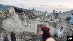 Afganos revisan la destrucción causada por un terremoto en la provincia de Paktika, en el este de Afganistán, el 22 de junio de 2022. (Agencia Noticiosa Bakhtar vía AP)