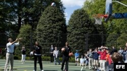Barack Obama tira a canasta durante un partido de baloncesto con los miembros del equipo Harlem Globtrotters durante el llamado "Easter Egg Roll".