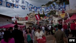 Varias personas caminan en Tegucigalpa (Honduras). Las votaciones generales en el país finalizaron con una masiva afluencia de votantes y sin mayores incidentes.