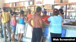 Residentes hacen fila para adquirir alimentos racionados en una bodega de Holguín. 