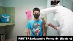 Cristian Artimbau, de 14 años, recibe una dosis de la vacuna Soberana 02. (Reuters/Alexandre Meneghini).