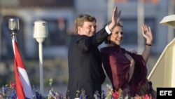 El rey Guillermo-Alejandro de Holanda (i) y la reina Máxima (d), saludan a los espectadores durante su paseo en barco por el río Ij hoy, martes 30 de abril de 2013, tras la ceremonia en la que Guillermo-Alejandro fue proclamado rey