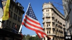 Una bandera de Estados Unidos ondea sobre un bicitaxi en una calle de La Habana.