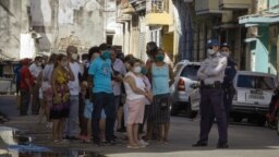 Desde que las abrieron el 20 de julio, cuando fue tomada esta foto, las tiendas que venden alimentos y artículos de primera necesidad en dólares han tenido largas colas custodiadas por policías y militares (Adalberto Roque/AFP).